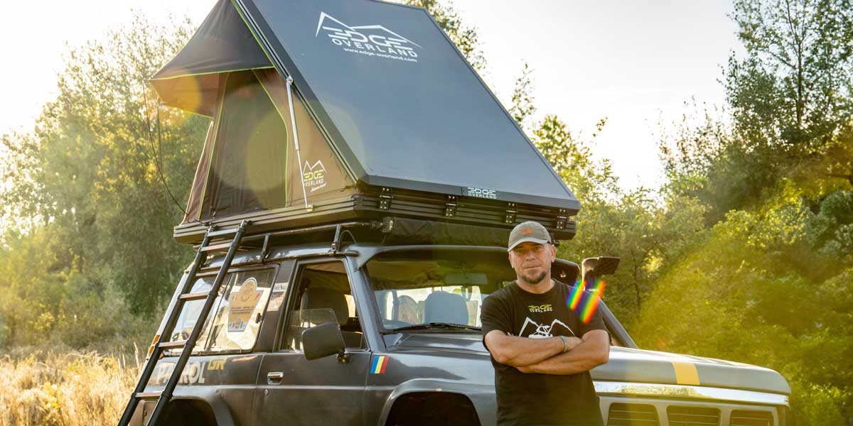Florin Pop Vancea standing beside his car equipped with the EDGE Overland rooftop tent