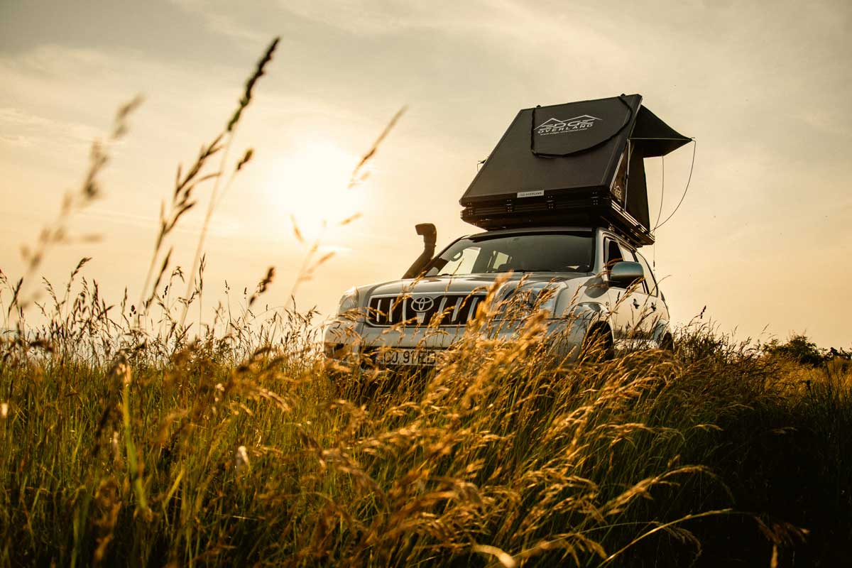 Explore One Car Tent camping on a hilltop in high grass