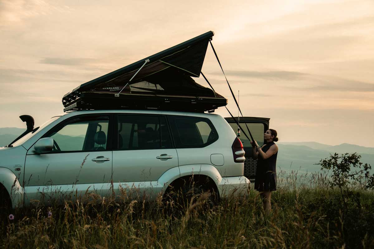 Explore One rooftop tent being opened by a camper at sunset
