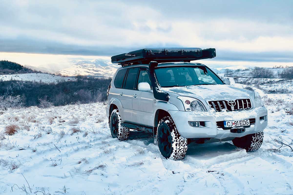 Explore One Rooftop tent on top of an SUV in a winter landscape