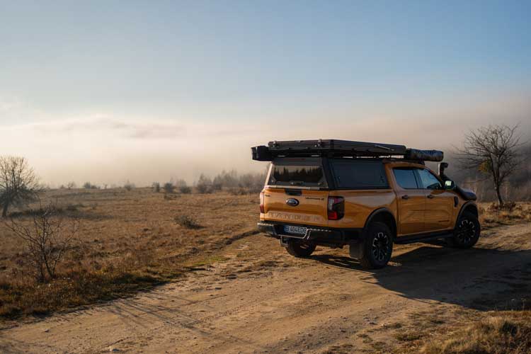 Vista escénica de la tienda de techo Explore One durante overlanding en colinas con niebla.