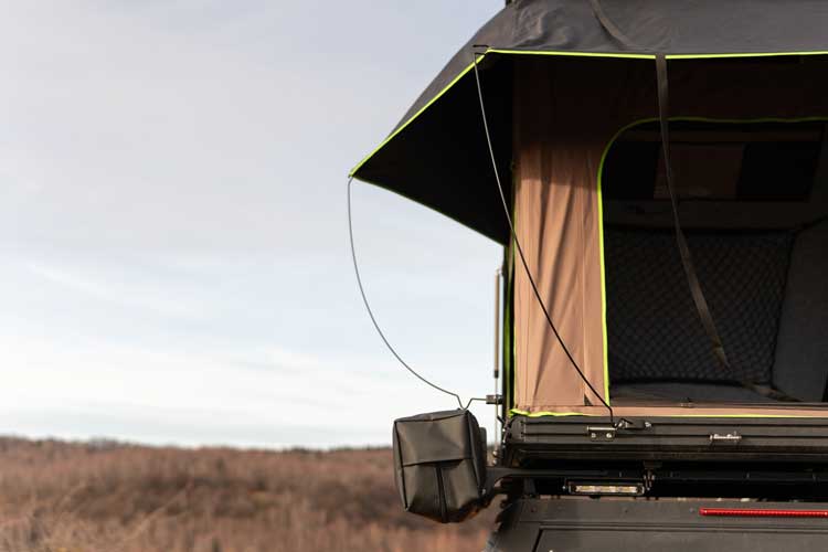 Vue à distance du rehausseur de mât monté sur une tente de toit avec un auvent sur le côté.