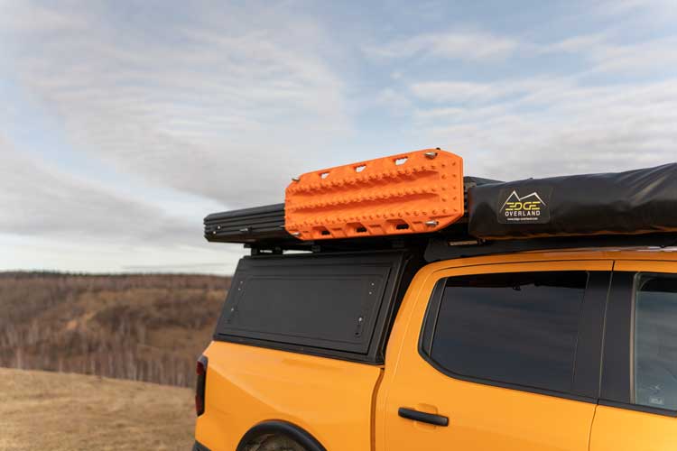 Right hand side view of two traction boards mounted on an overlanding vehicle rooftop tent.