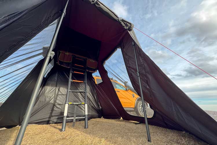 Panoramica da un'angolazione bassa dell'annesso per la tenda da tetto Horizon Mini mentre viene dispiegato sulla tenda