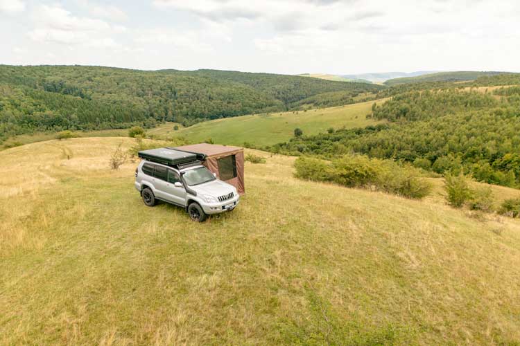 Vedere panoramică a pereților laterali pe o marchiza Shelter Max pe vârful unui deal cu o priveliște frumoasă